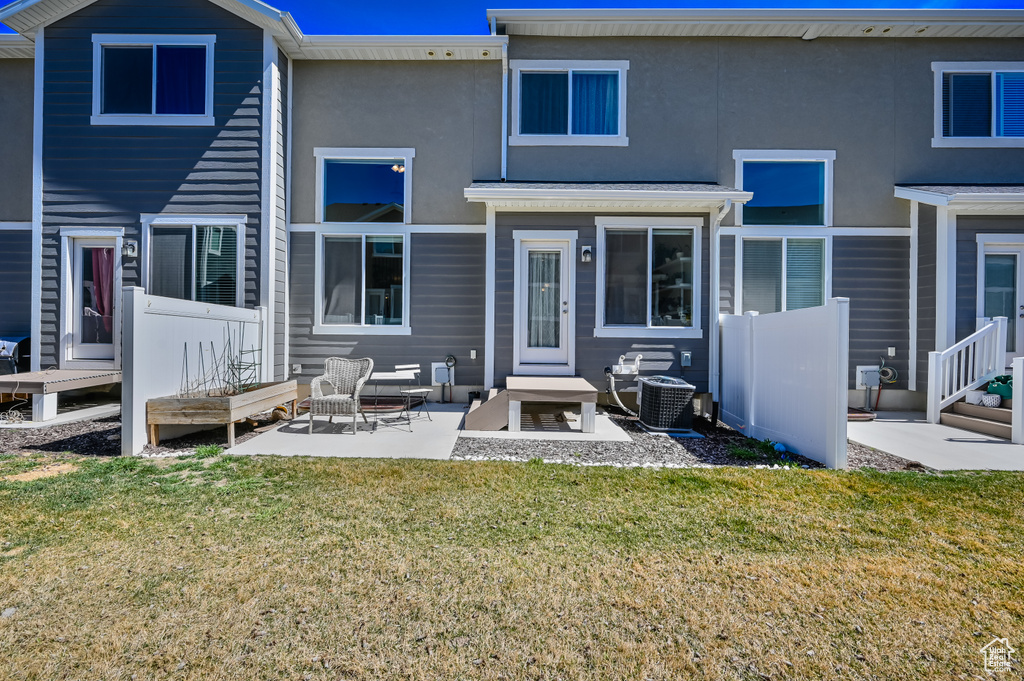 Rear view of property with a yard, a patio, and stucco siding