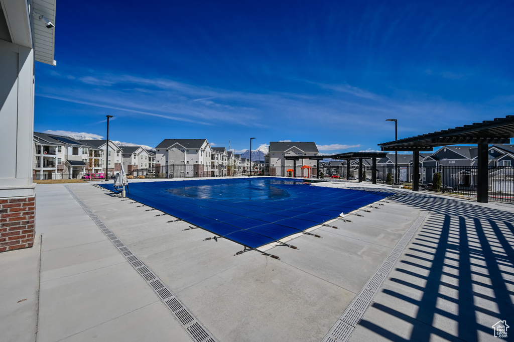 Community pool with a residential view, a pergola, and a patio area
