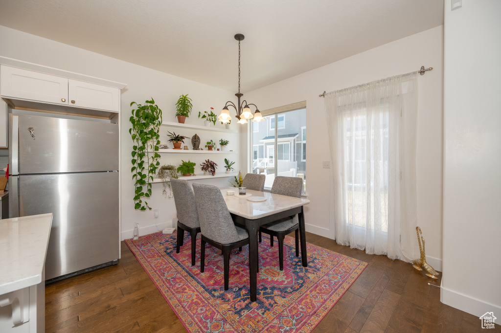 Dining room featuring a chandelier and dark wood-style flooring