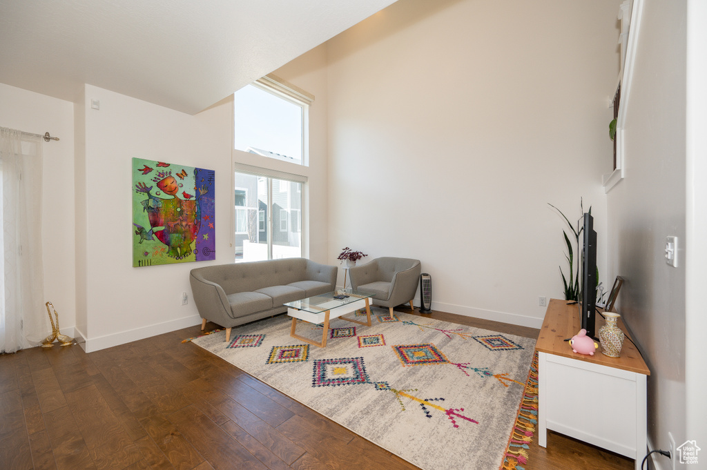 Living area with wood finished floors and a towering ceiling