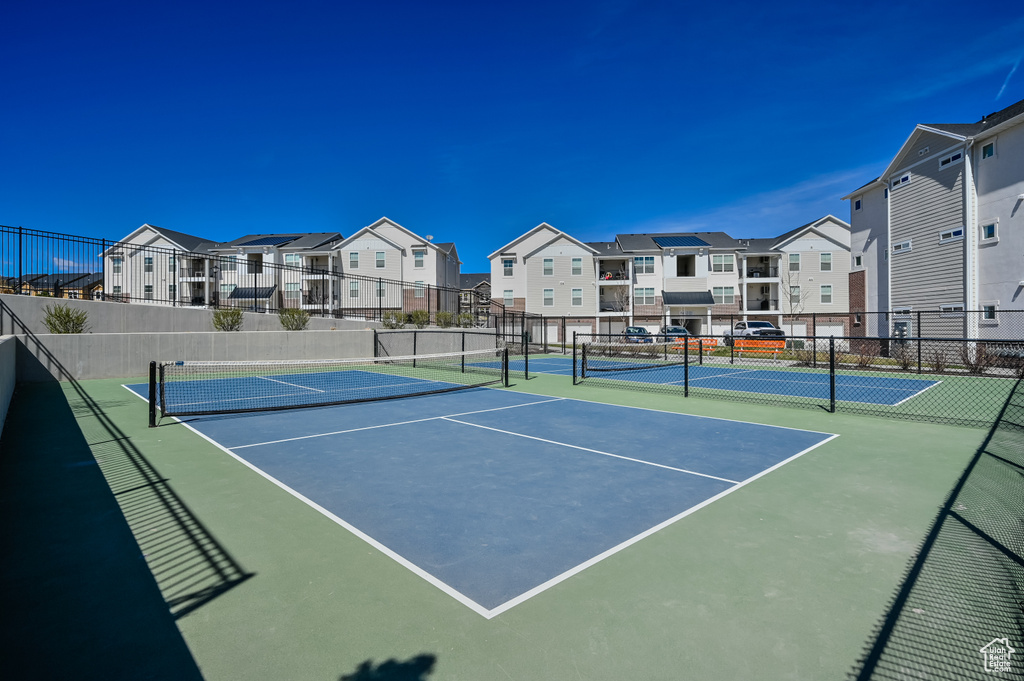View of tennis court featuring a residential view