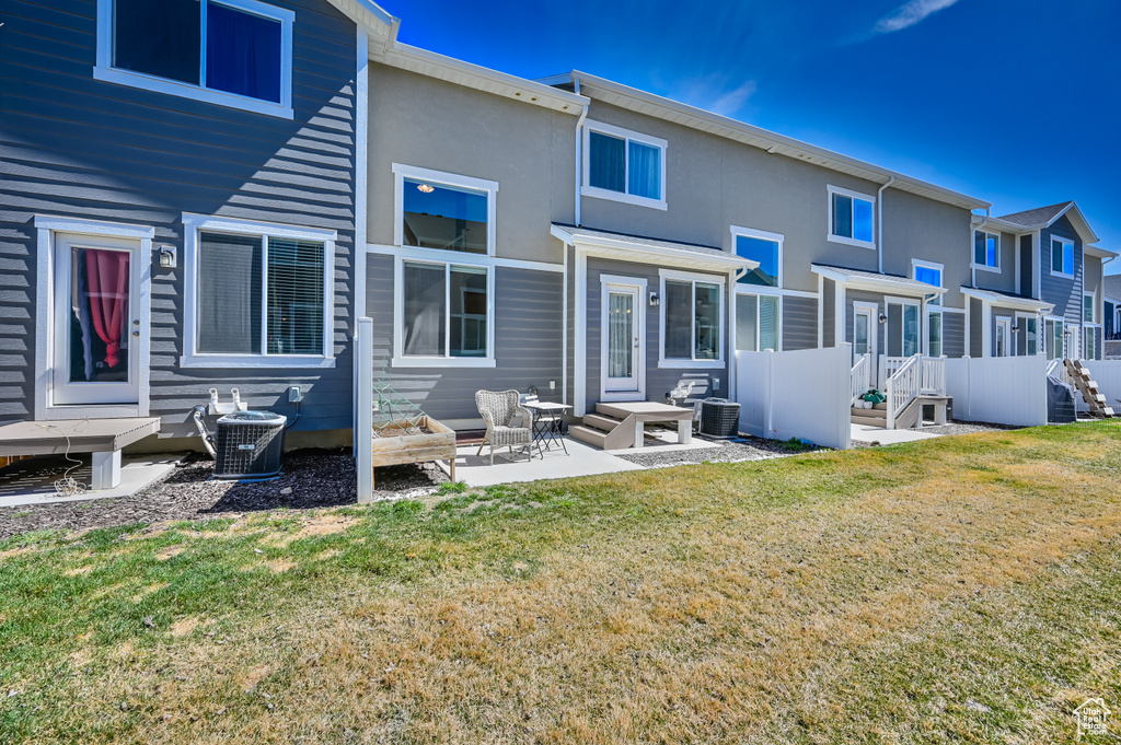 Rear view of house featuring a yard and stucco siding