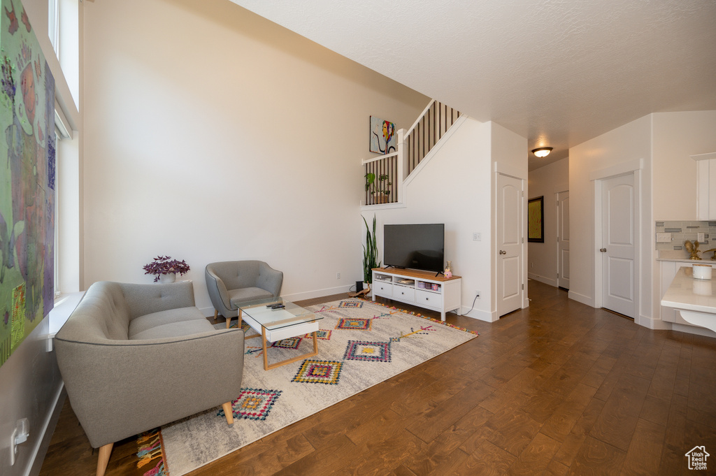 Living room with dark wood-type flooring and baseboards