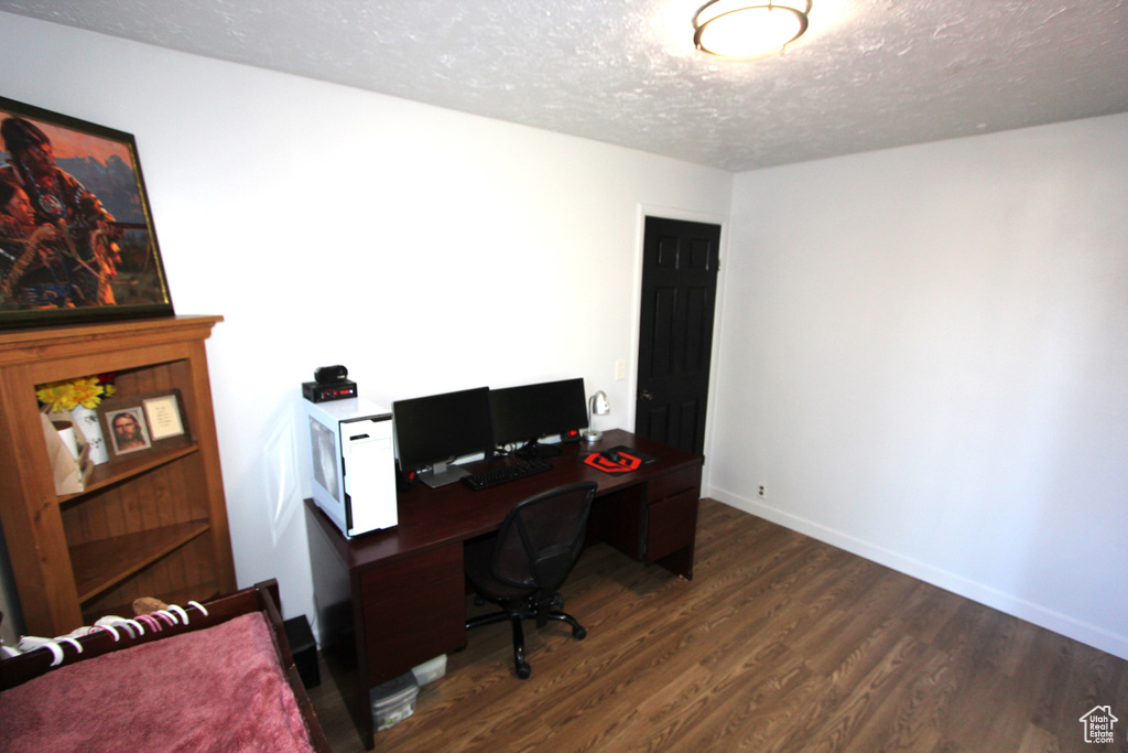 Office featuring a textured ceiling and dark wood-type flooring