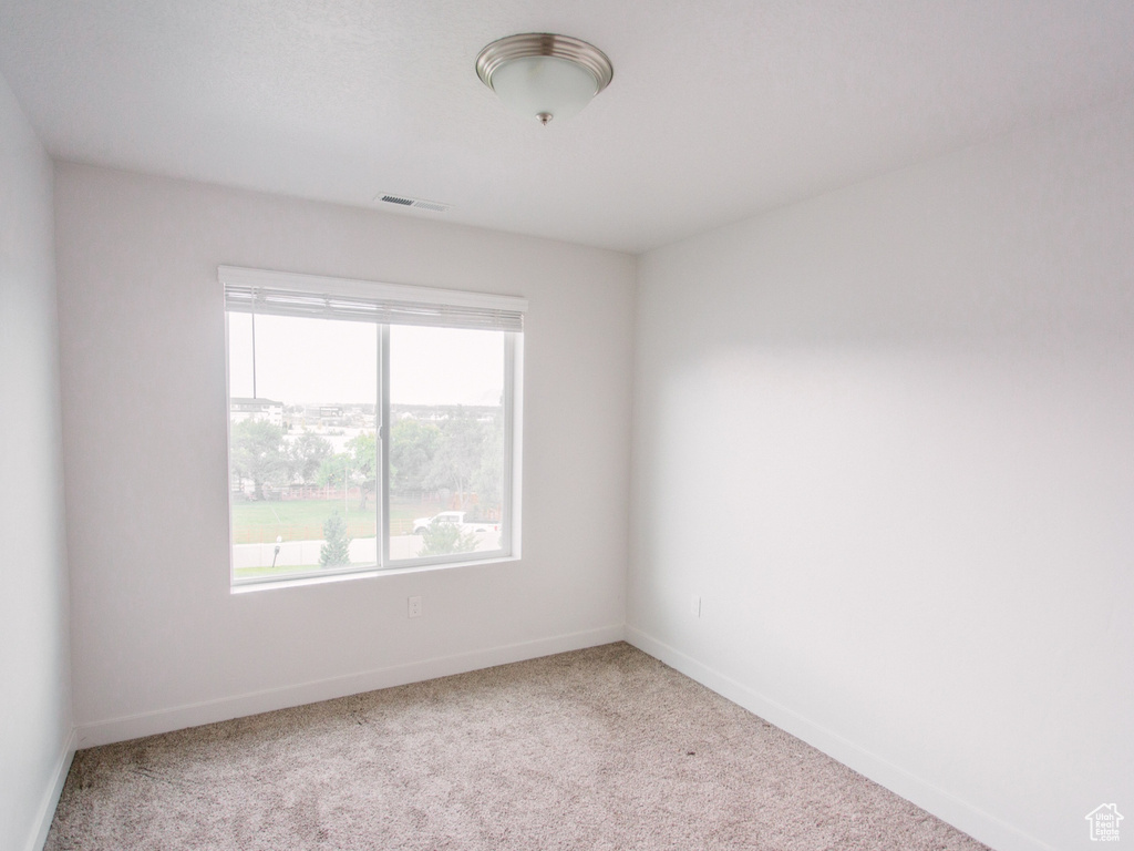 Empty room featuring carpet flooring and baseboards
