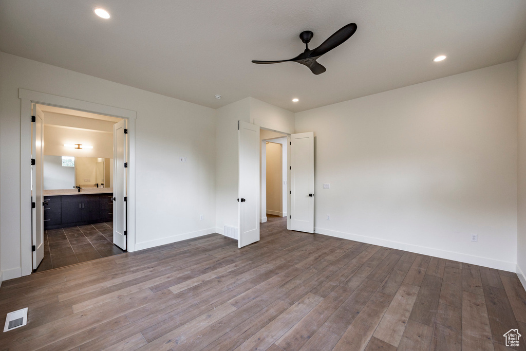 Unfurnished bedroom with dark wood-style floors, connected bathroom, recessed lighting, and a ceiling fan