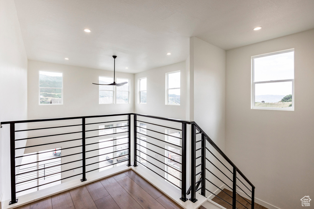 Stairway featuring plenty of natural light, recessed lighting, and wood finished floors