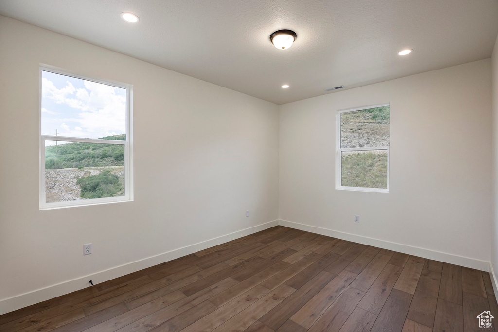 Empty room with dark wood finished floors and recessed lighting
