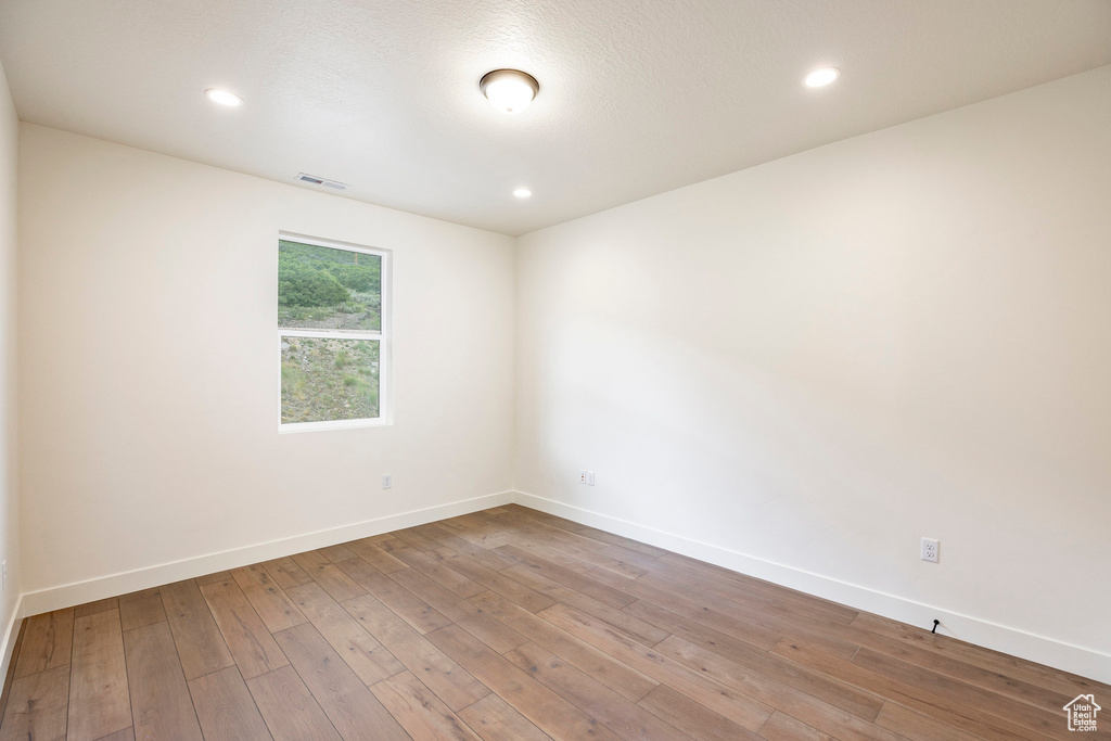 Empty room featuring hardwood / wood-style flooring and recessed lighting