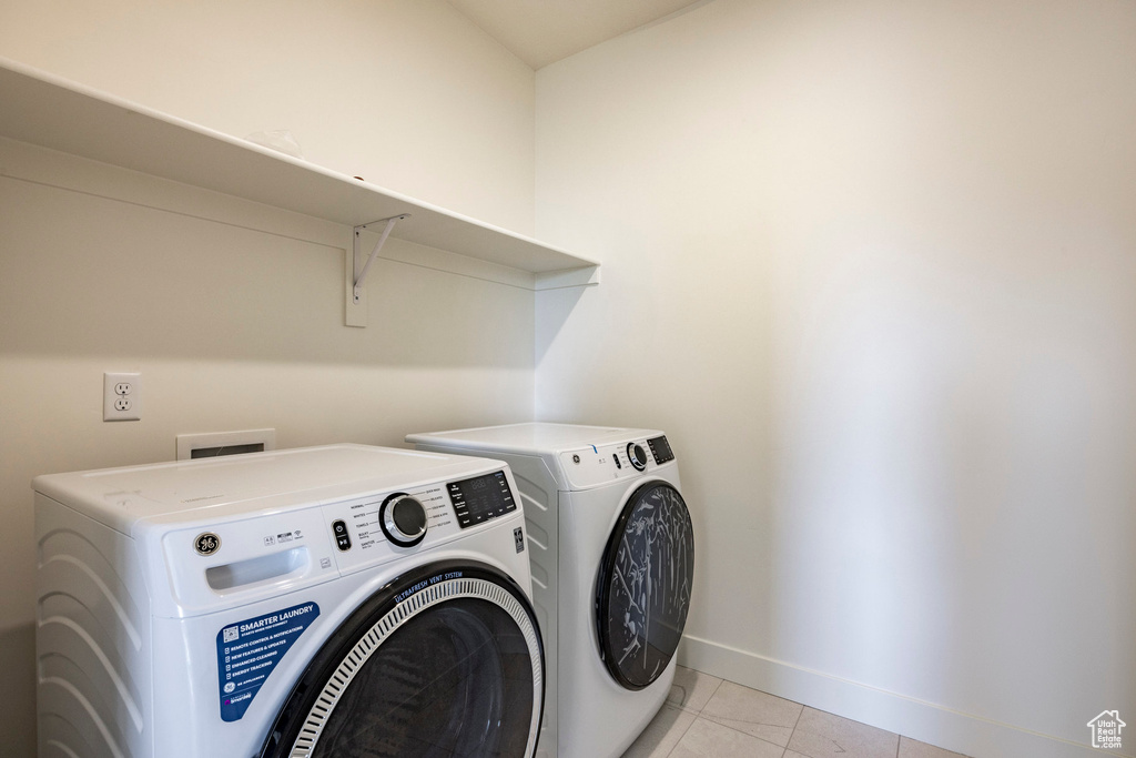 Laundry room featuring separate washer and dryer and light tile patterned floors