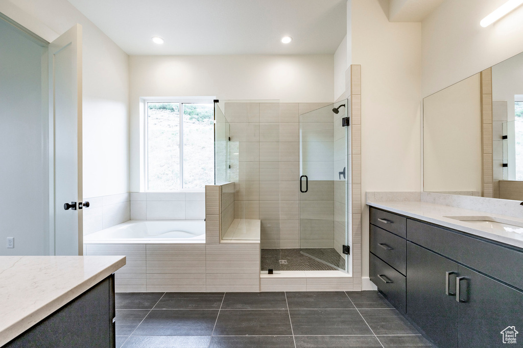 Bathroom featuring vanity, a garden tub, a shower stall, tile patterned flooring, and recessed lighting