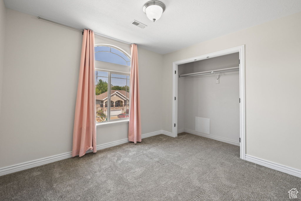 Unfurnished bedroom featuring carpet flooring and a closet