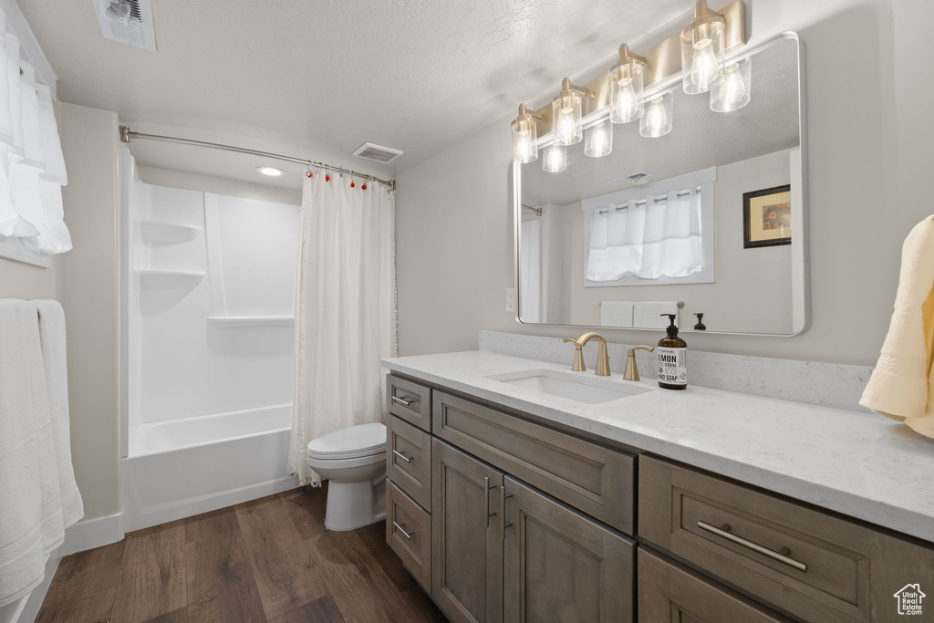 Bathroom featuring vanity, wood finished floors, and shower / bath combo with shower curtain
