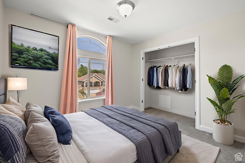 Carpeted bedroom with baseboards and a closet
