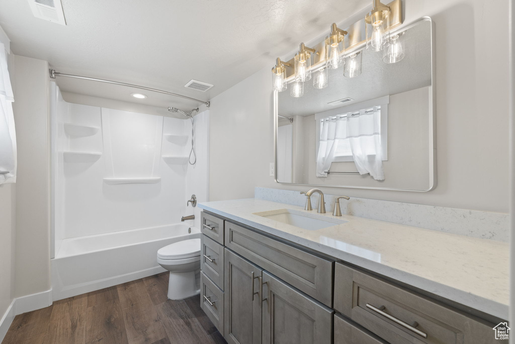 Bathroom with vanity, wood finished floors, shower / tub combination, and recessed lighting