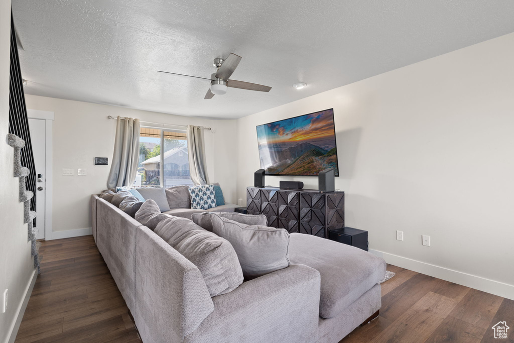 Living area with ceiling fan, a textured ceiling, and wood finished floors