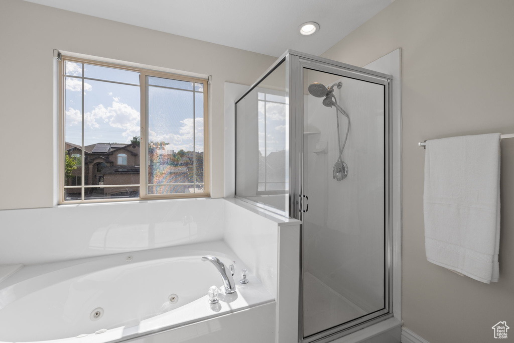 Bathroom featuring a stall shower and a whirlpool tub