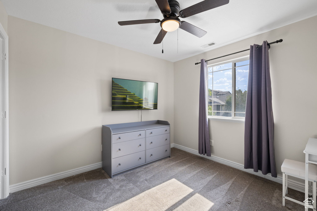 Carpeted bedroom featuring baseboards and a ceiling fan