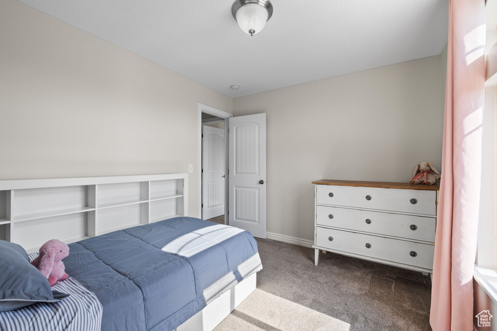 Bedroom featuring carpet and baseboards