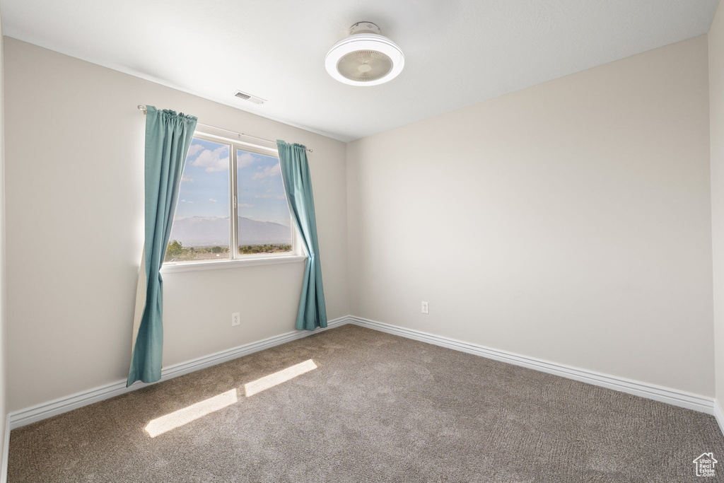Spare room featuring carpet floors and baseboards