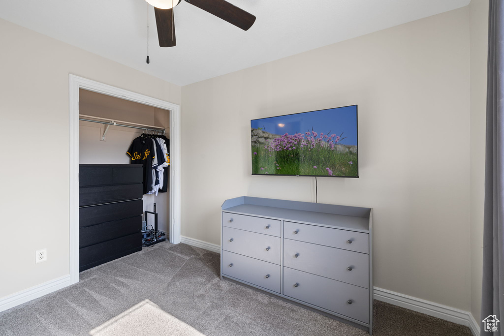 Carpeted bedroom featuring a closet and ceiling fan