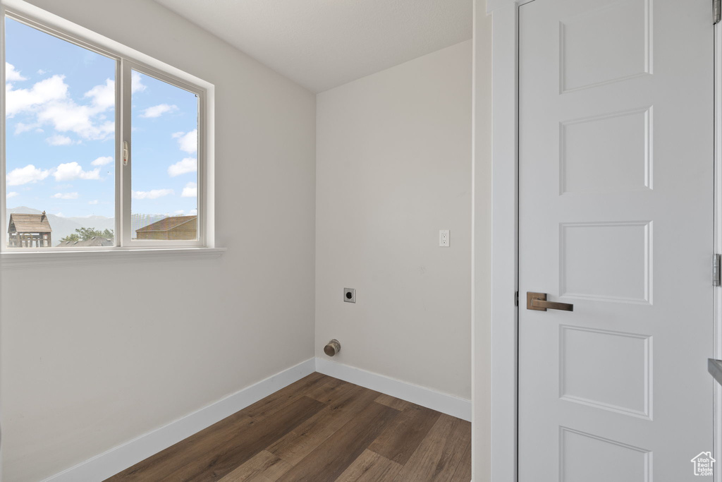 Laundry room featuring electric dryer hookup and dark wood-type flooring