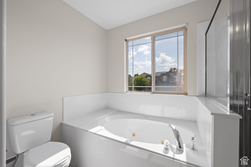 Bathroom featuring toilet and a jetted tub
