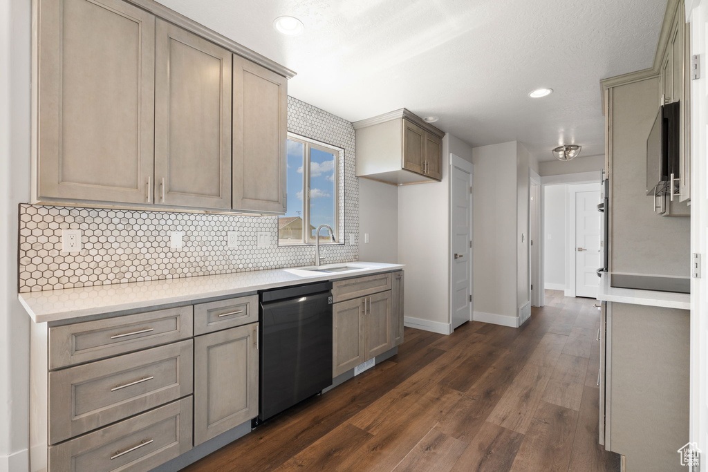 Kitchen with stainless steel dishwasher, decorative backsplash, dark wood-style flooring, light countertops, and recessed lighting