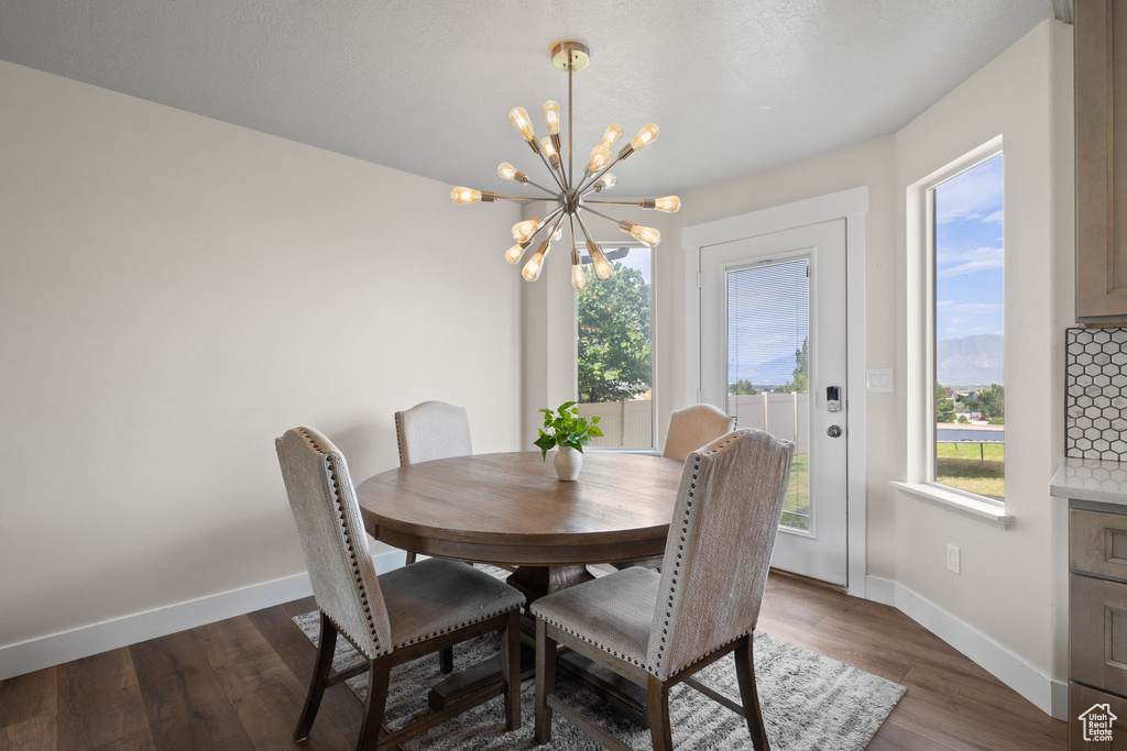 Dining area featuring a chandelier and dark wood-style flooring