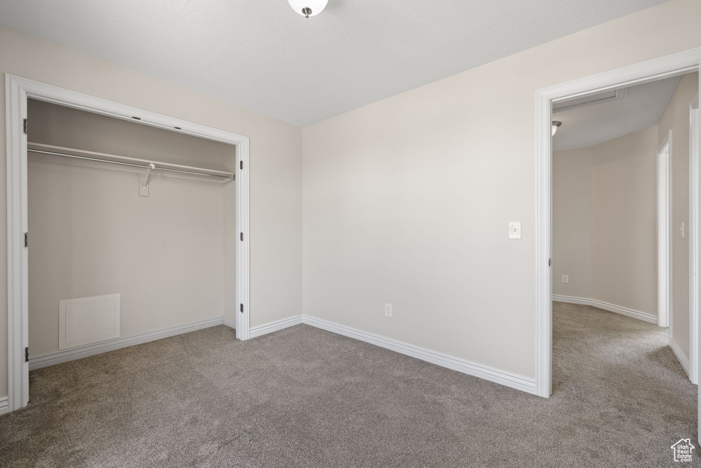 Unfurnished bedroom featuring carpet floors and a closet