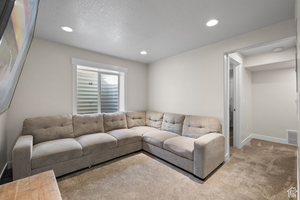 Carpeted living area featuring recessed lighting and baseboards