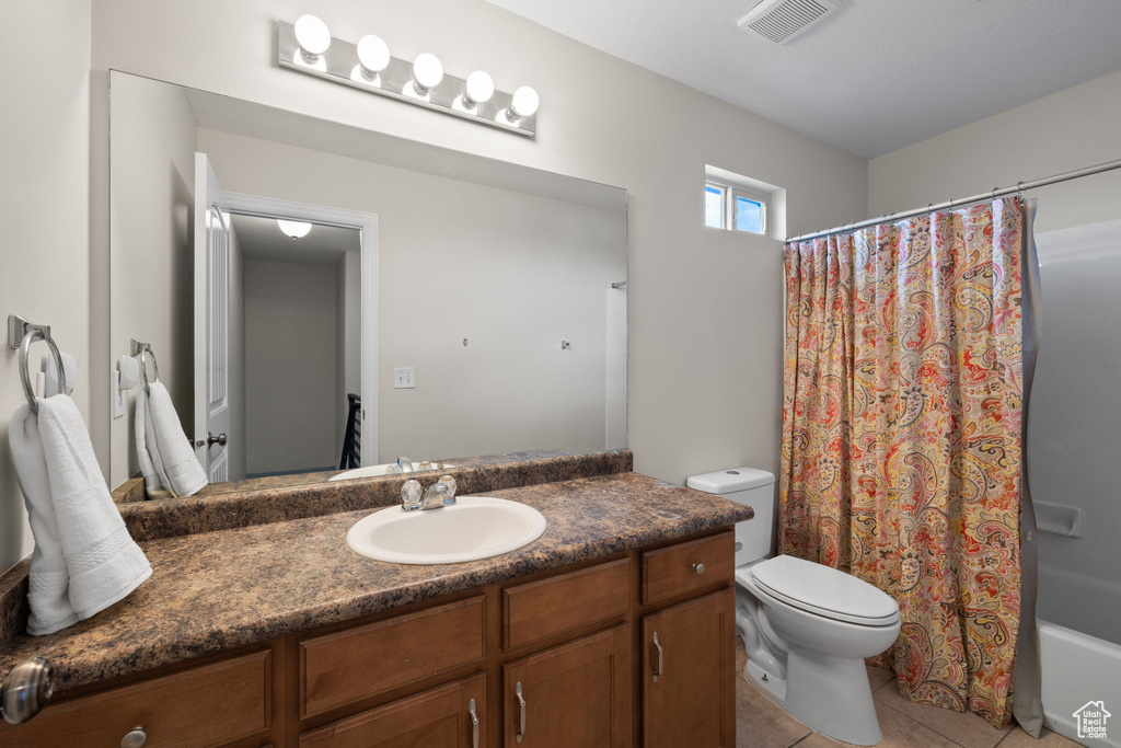 Full bathroom featuring vanity, tile patterned flooring, and shower / bathtub combination with curtain