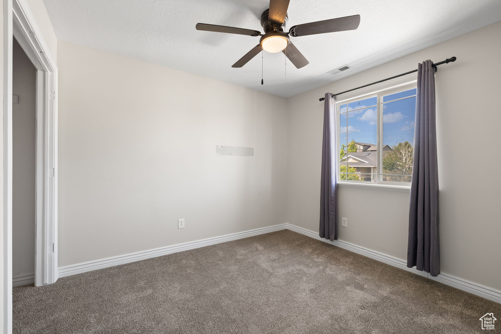 Unfurnished room with carpet and a ceiling fan