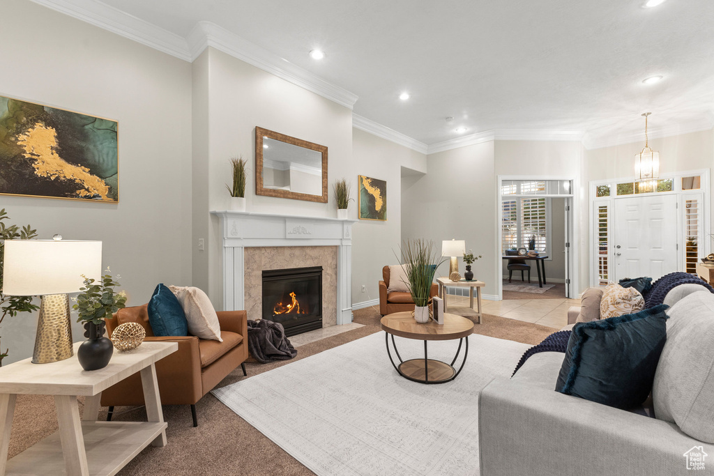 Living area featuring recessed lighting, a fireplace, crown molding, light carpet, and a chandelier