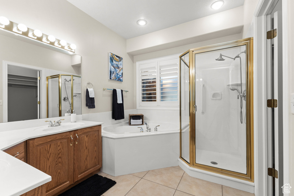 Full bathroom featuring a stall shower, a bath, vanity, and tile patterned floors