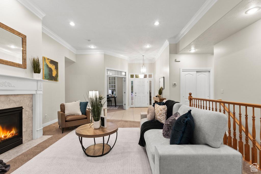 Living room with recessed lighting, ornamental molding, a fireplace, and light tile patterned floors