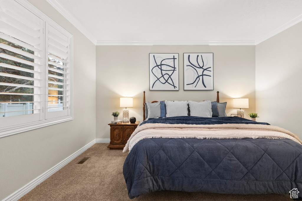 Carpeted bedroom with ornamental molding