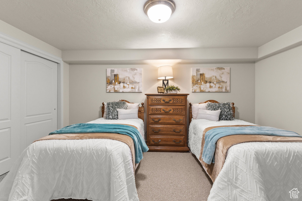 Carpeted bedroom featuring a closet and a textured ceiling