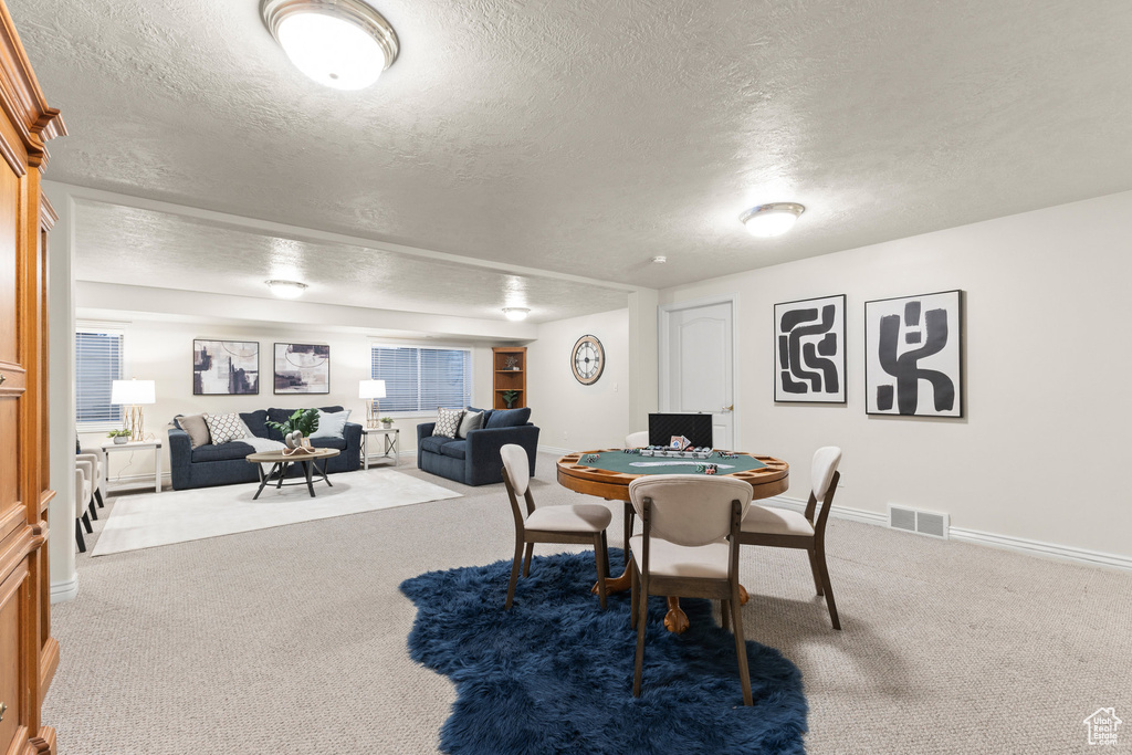 Dining space with carpet flooring and a textured ceiling
