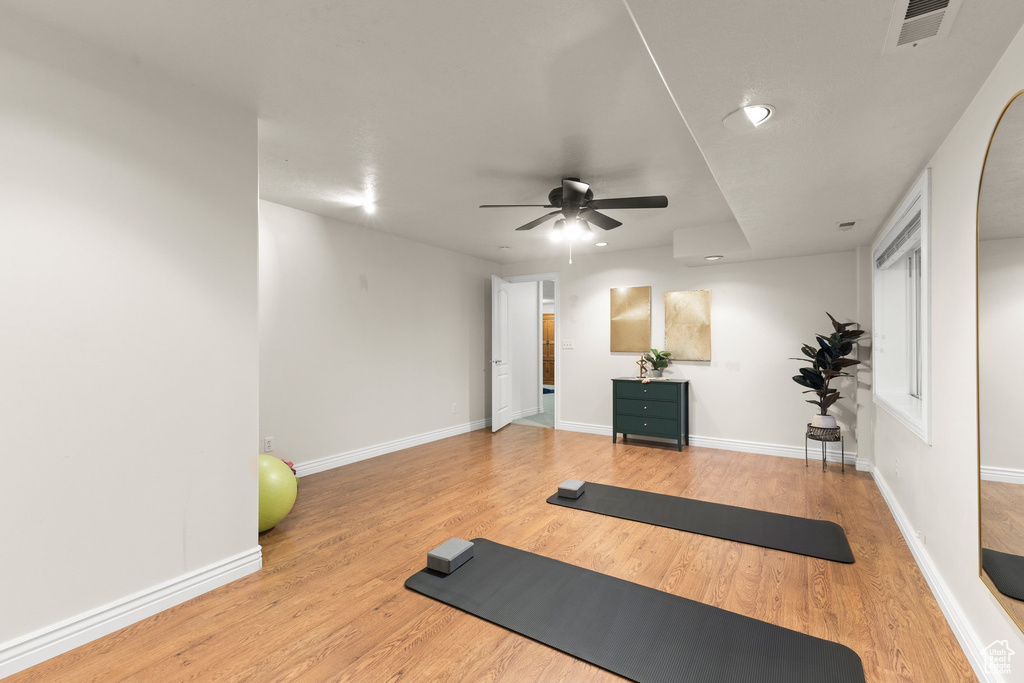 Workout room with ceiling fan and wood finished floors
