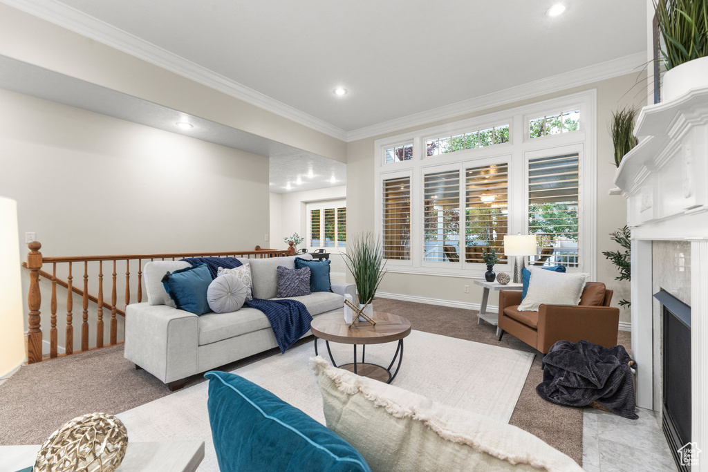 Living area with crown molding, a fireplace, plenty of natural light, recessed lighting, and carpet floors