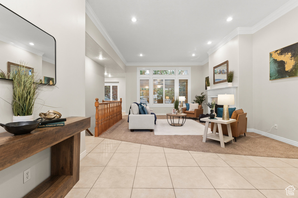 Living area with recessed lighting, ornamental molding, light tile patterned floors, and light carpet