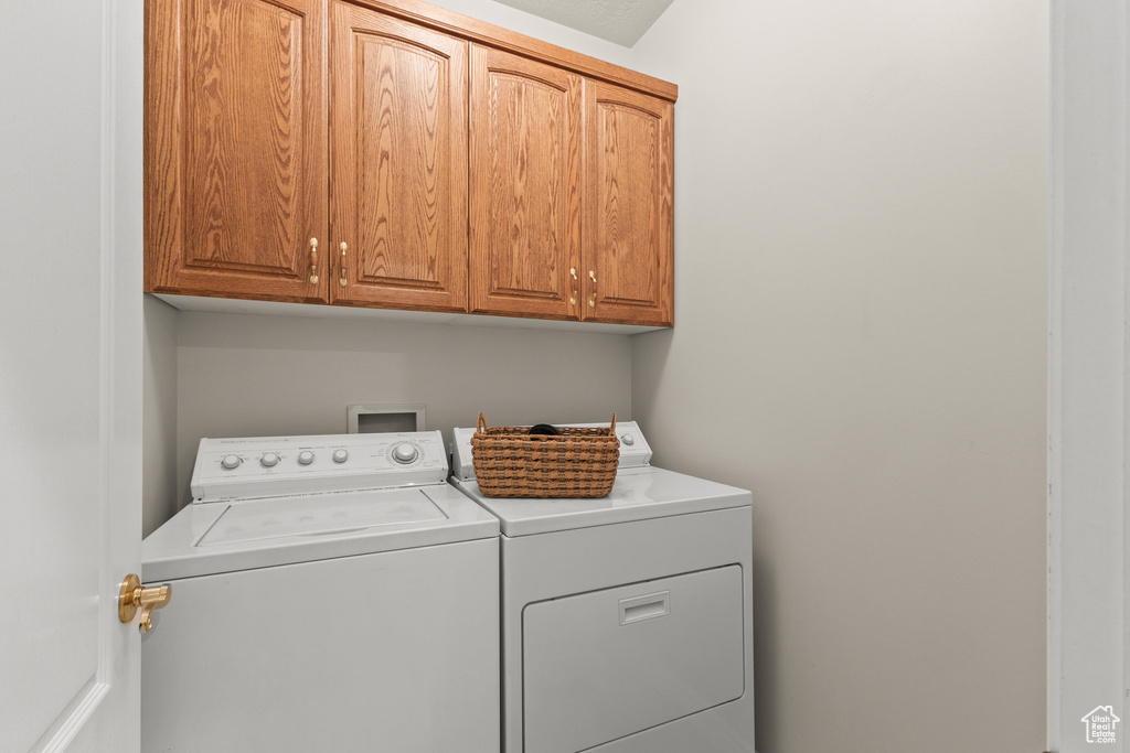 Laundry room with independent washer and dryer and cabinet space