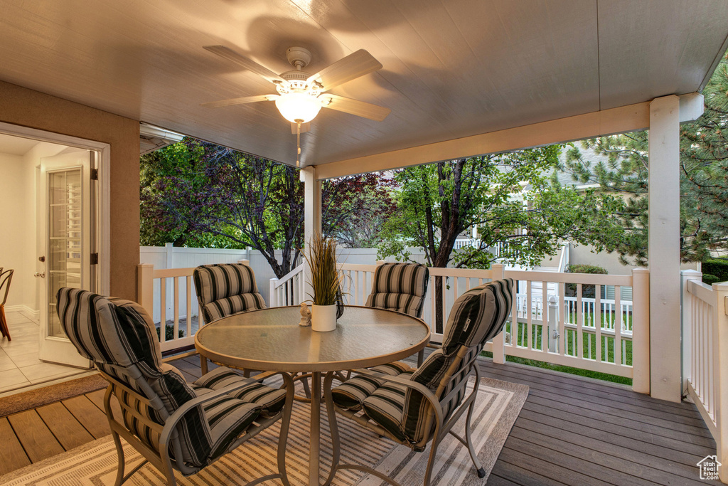 Wooden deck with outdoor dining area and ceiling fan