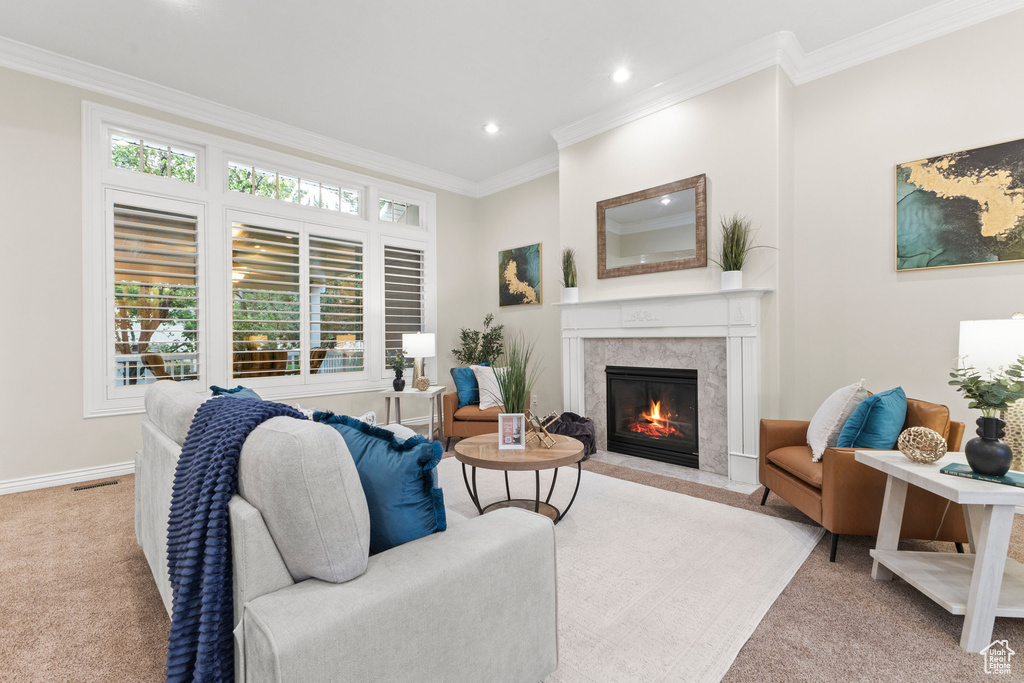 Carpeted living room featuring ornamental molding, a high end fireplace, and recessed lighting