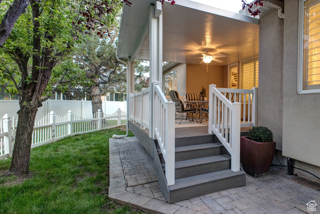 Exterior space featuring stucco siding and a ceiling fan