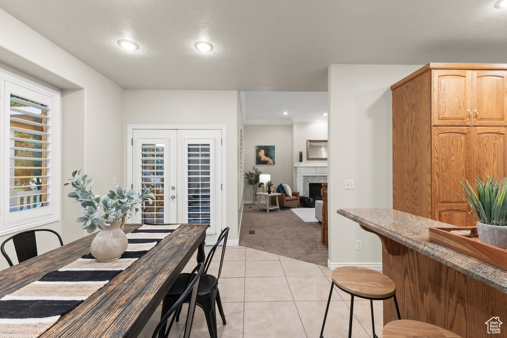 Dining room with light carpet, light tile patterned floors, recessed lighting, and a fireplace