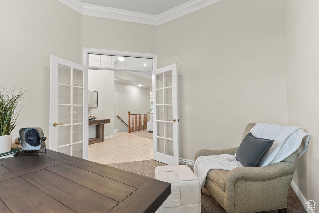 Home office featuring french doors, ornamental molding, light tile patterned floors, and a towering ceiling