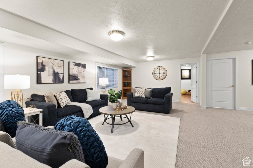 Living room with a textured ceiling and light colored carpet