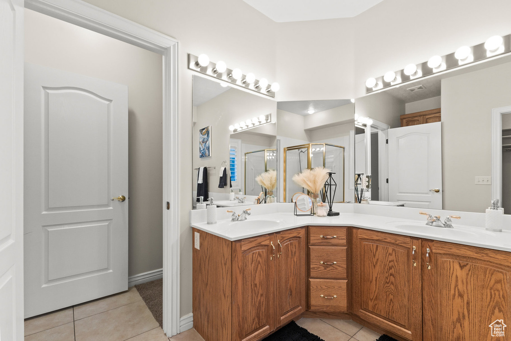 Full bathroom with tile patterned flooring, double vanity, and a stall shower